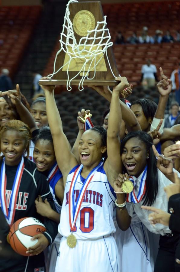 Senior Morgan Bolton holds up the State Championship trophy in front of her team on the floor of UT Austin's Frank Erwin Center Saturday. The team claimed their first State Championship since 2003. (Abigail Padgett photo)