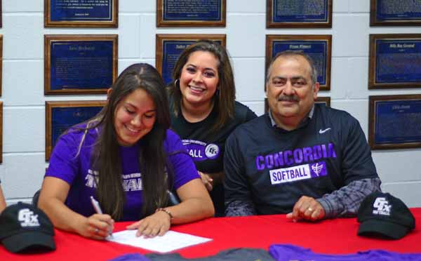 Senior Valerie Gonzales signs her letter of intent to play for Concordia University as her parents look on.  (Cody Rogers Photo)