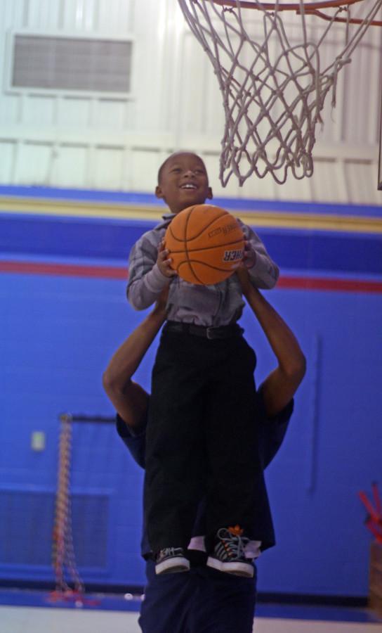 HOSA President Roderick Coleman helping a Hastings Elementary Husky to make a basket. (Bria Norman photo)