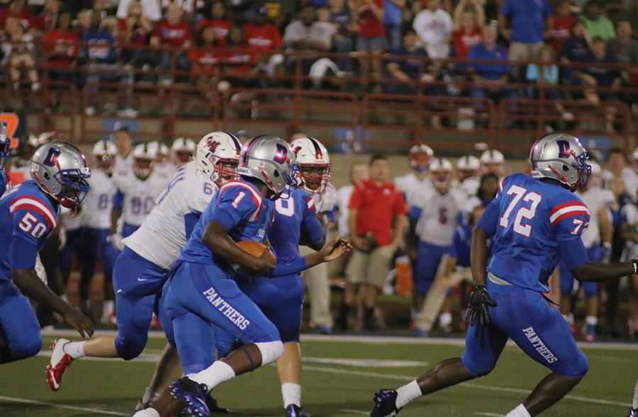 Varsity quarterback Mike Meyers scrambles with the ball in game against Waco Midway. The Panthers went on to lose this game at home. (photo by Ricardo Martin)