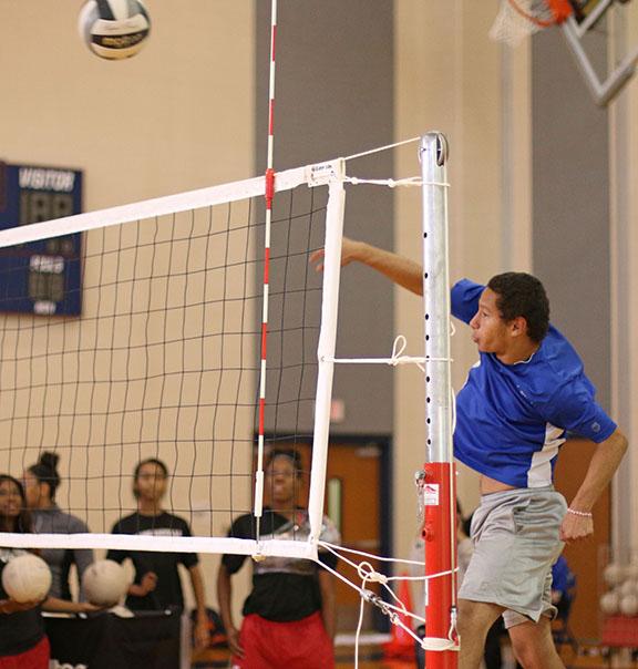 Senior Alexander Fuentes spikes the ball over the net during Powderbuff practice. (Photo by: Kyhia Jackson)