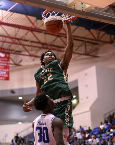 Senior Elijah Caldwell defends the basket as DeSoto's Marques Bolden dunks during a tough district loss. Photo By Cynthia Rangel