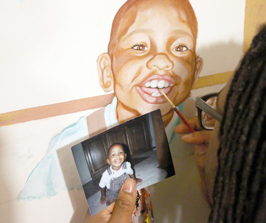 Senior Kalen McGuire focuses his eyes on the final touches of his painting of himself. (Trevon McWilliams photo)