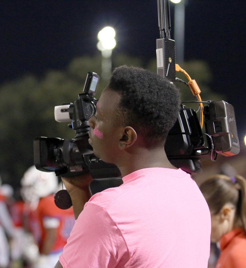 Ricardo Martin works a video camera on the field of the Duncanville Vs. DeSoto football game for the scoreboard. (Emlyn Almanza photo)