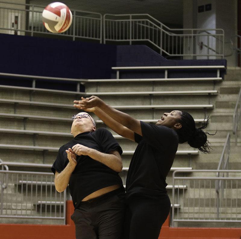 Art teacher Yolanda Harris and History teacher David Wallner collide while trying to push the ball over the net against the students in the Faculty vs. student Powderbuff volleyball game. (Ruth Thunderhawk photo)