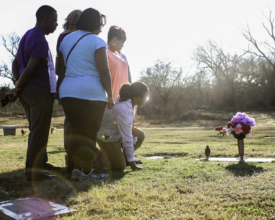 Senior Storm Malone kneels at the foot of his mother and sister's graves a few days after his mother's birthday. Every time he visits the grave he remembers the day four years ago when their lives were cut short in a tragic domestic violence shooting. Storm said he just wants to remember the joy they both brought to his life. (Alexis Rosebrock Photo)