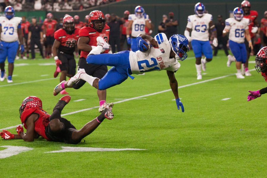 Javyn Square (21) hurdles a cedar hill defender at Globe Life Park.