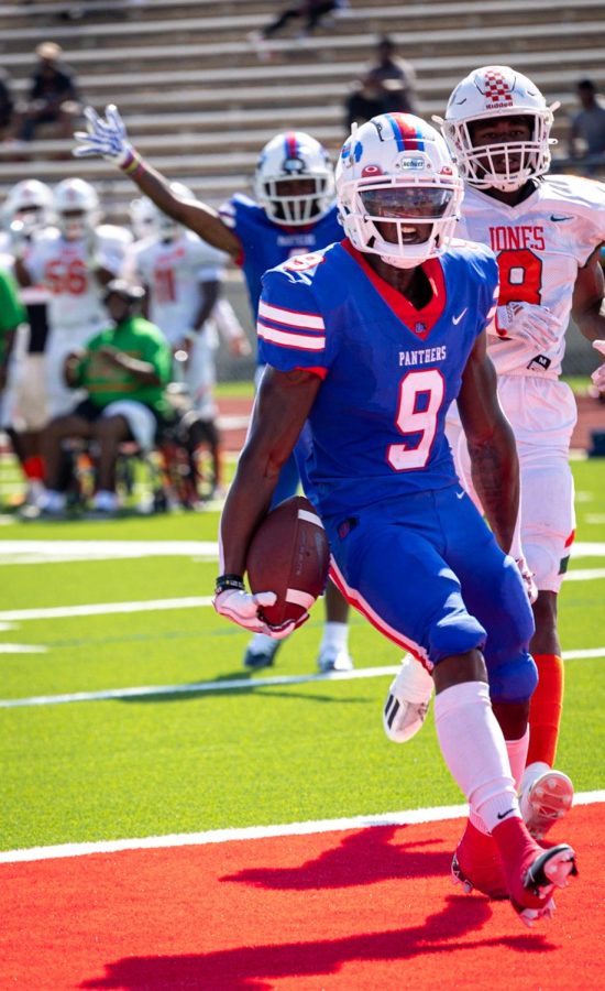 (9) Kaleb Kenny celebrates after scoring against Jones high school.