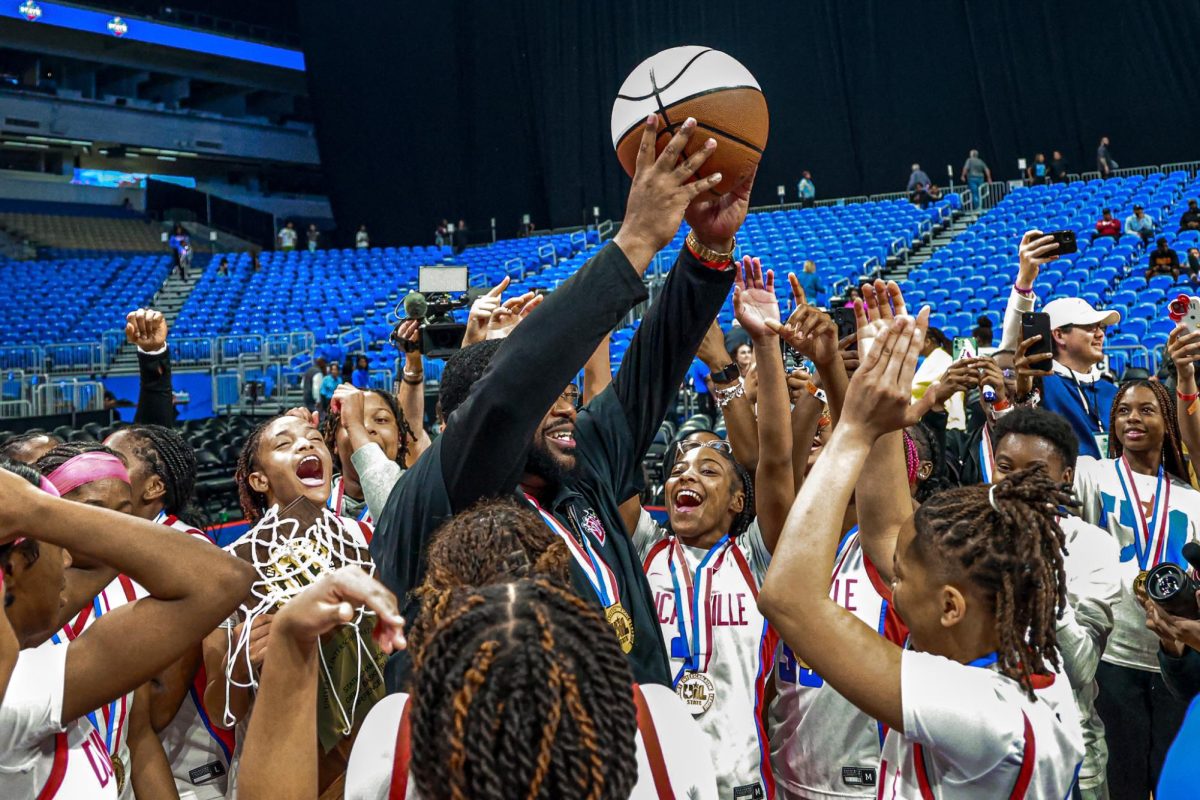 Coach Neiman Ford holds up the state championship ball after winning the 6A state championship.